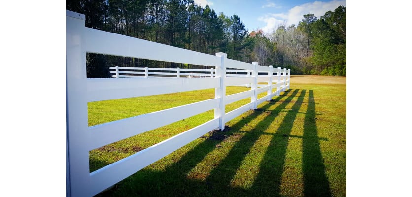 White 4-rail vinyl fencing installed in a field