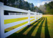 White 4-rail vinyl fencing installed in a field