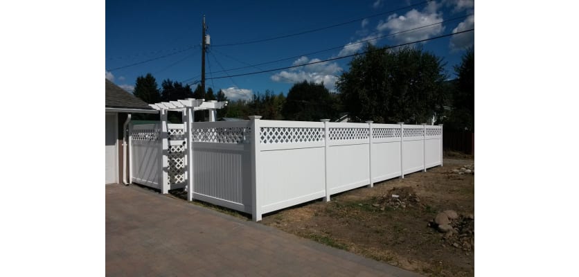 A NewStead Vinyl Privacy Walk Gate with Lattice Top in some yard fencing
