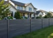 A row of NewStead Embossed Anthracite Grey Wood Plastic Composite Fencing around a home